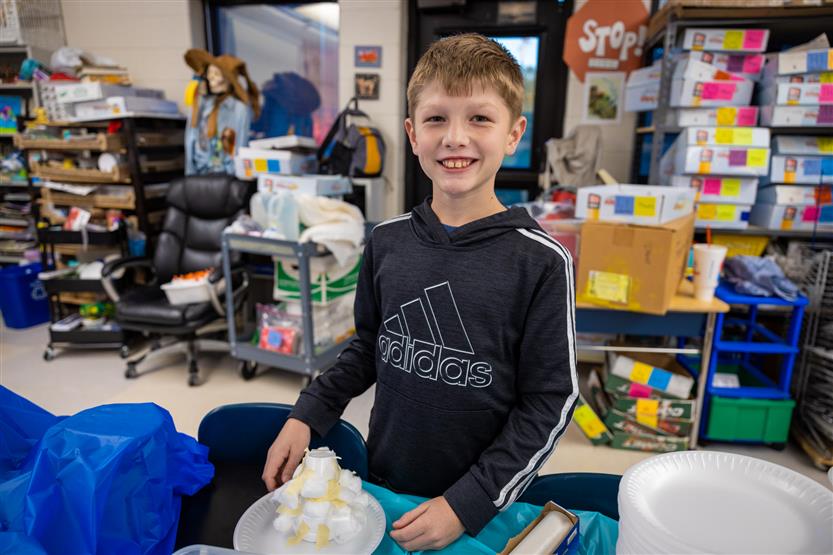 A boy wearing a black shirt smiles